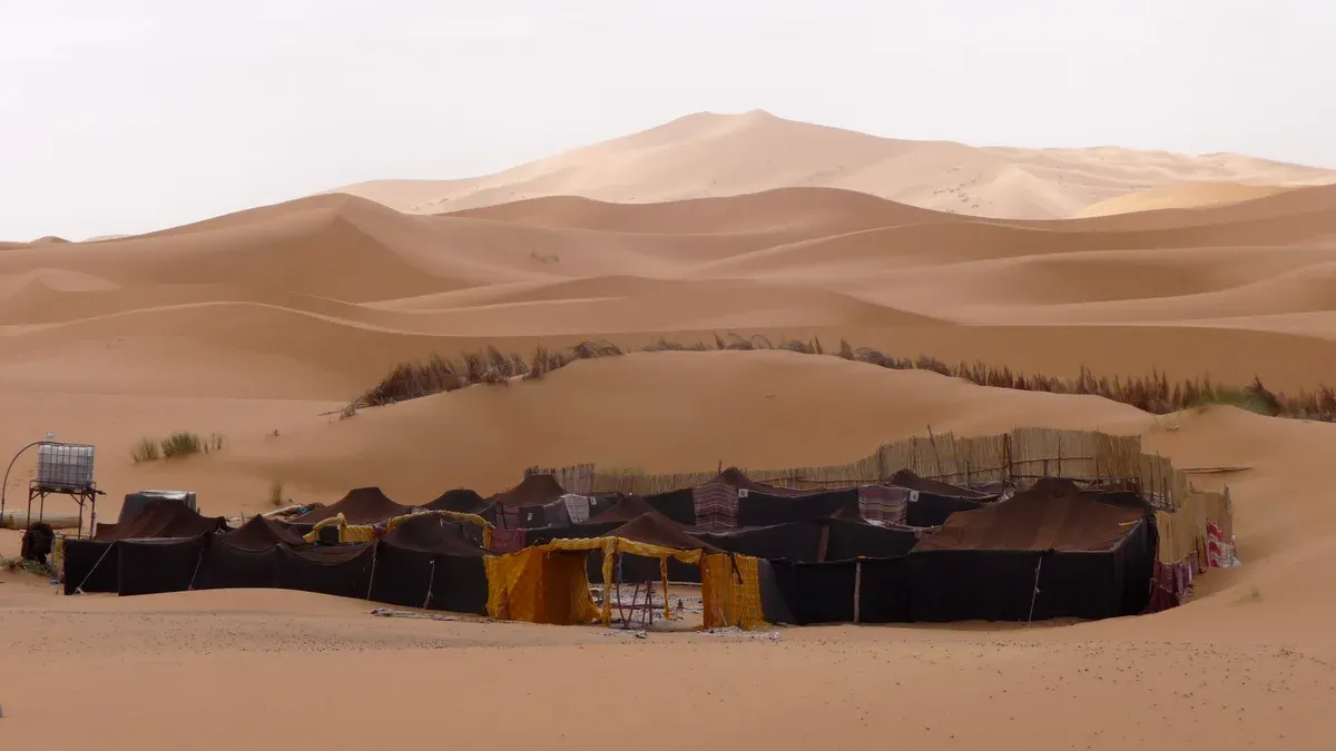 A black-tent Berber camp below the high dunes of Merzouga on a Morocco tour package, Berber camp, Merzouga, Morocco